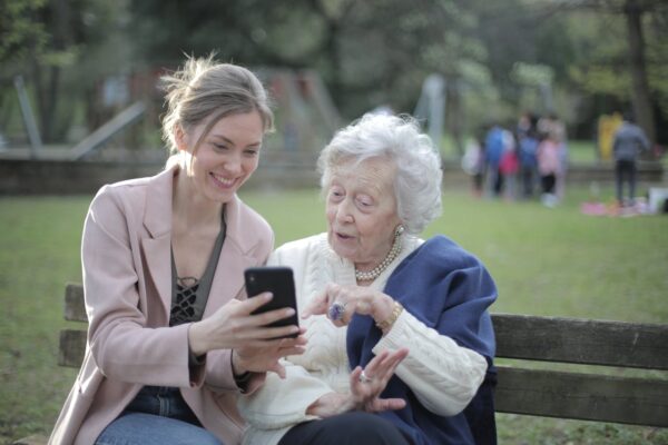 2 people on a bench looking at a phone